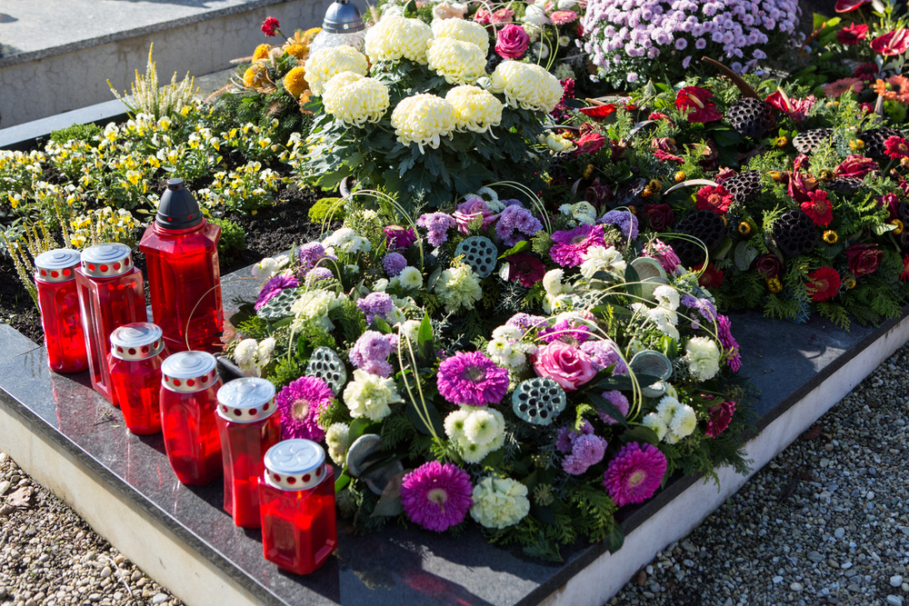 Blumen und Kerzen auf einem frischem Grab