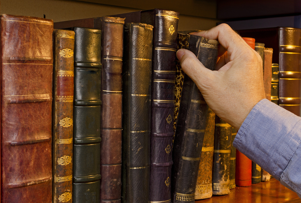 Jemand nimmt ein Buch aus einem Bücherregal